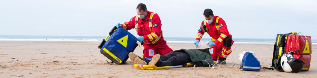 Critical Care Team Tending To Patient On Beach