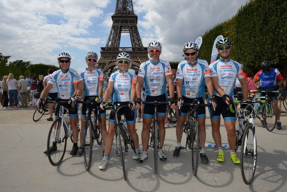 Cyclists With Bikes Smiling In Front Of The Eiffel Tower (1)