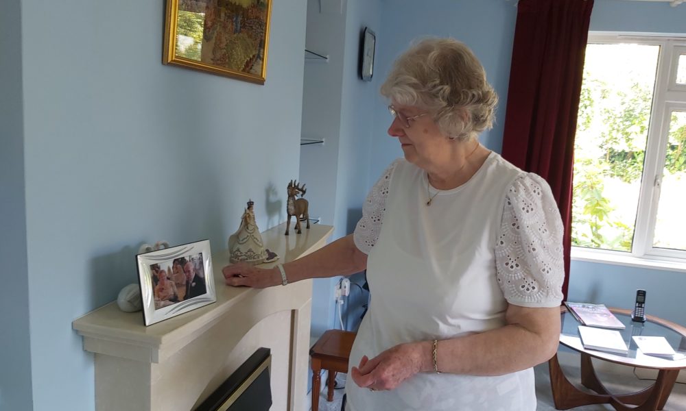 betty looking at photo on mantle piece