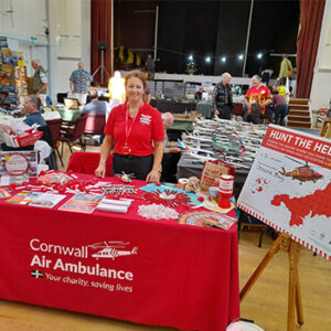 Cornwall Air Ambulance volunteer stood behind stall at an event