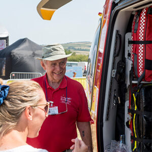 Cornwall Air Ambulance volunteer at event showing somebody the helicopter