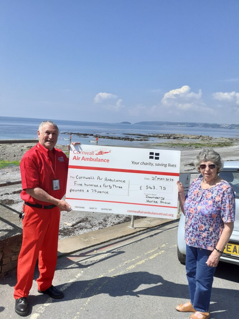 a man and woman standing next to a cheque sign having fundrasied