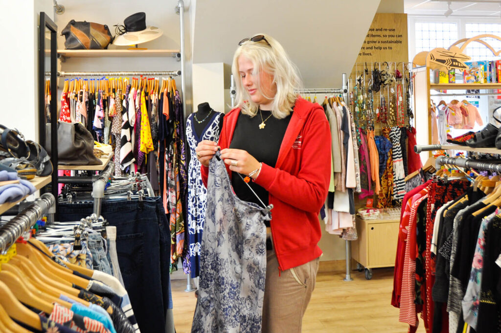 Volunteer Retail Shop Female Hanging Clothes